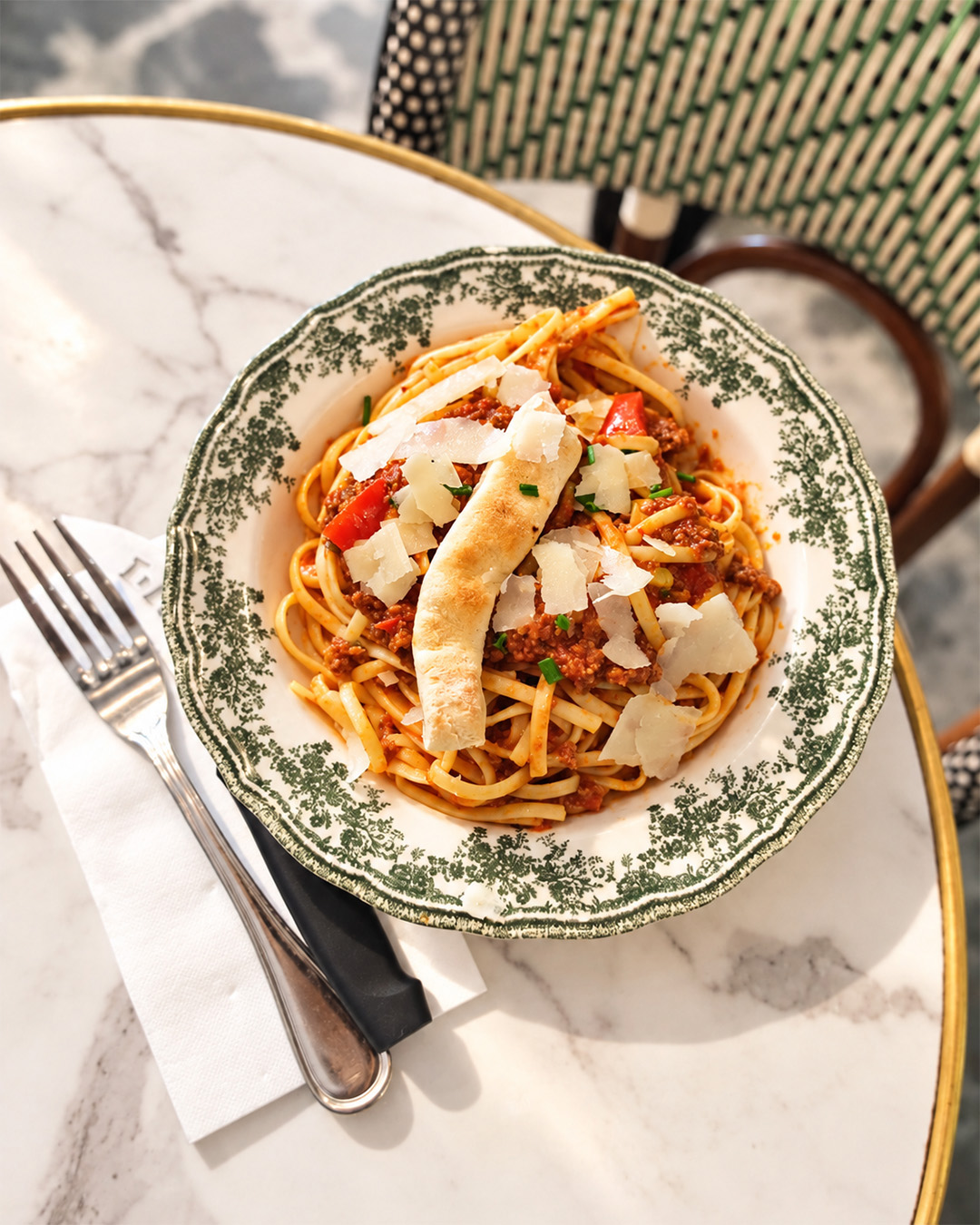 Assiette de pâtes à la sauce tomate et parmesan servie sur une table en marbre