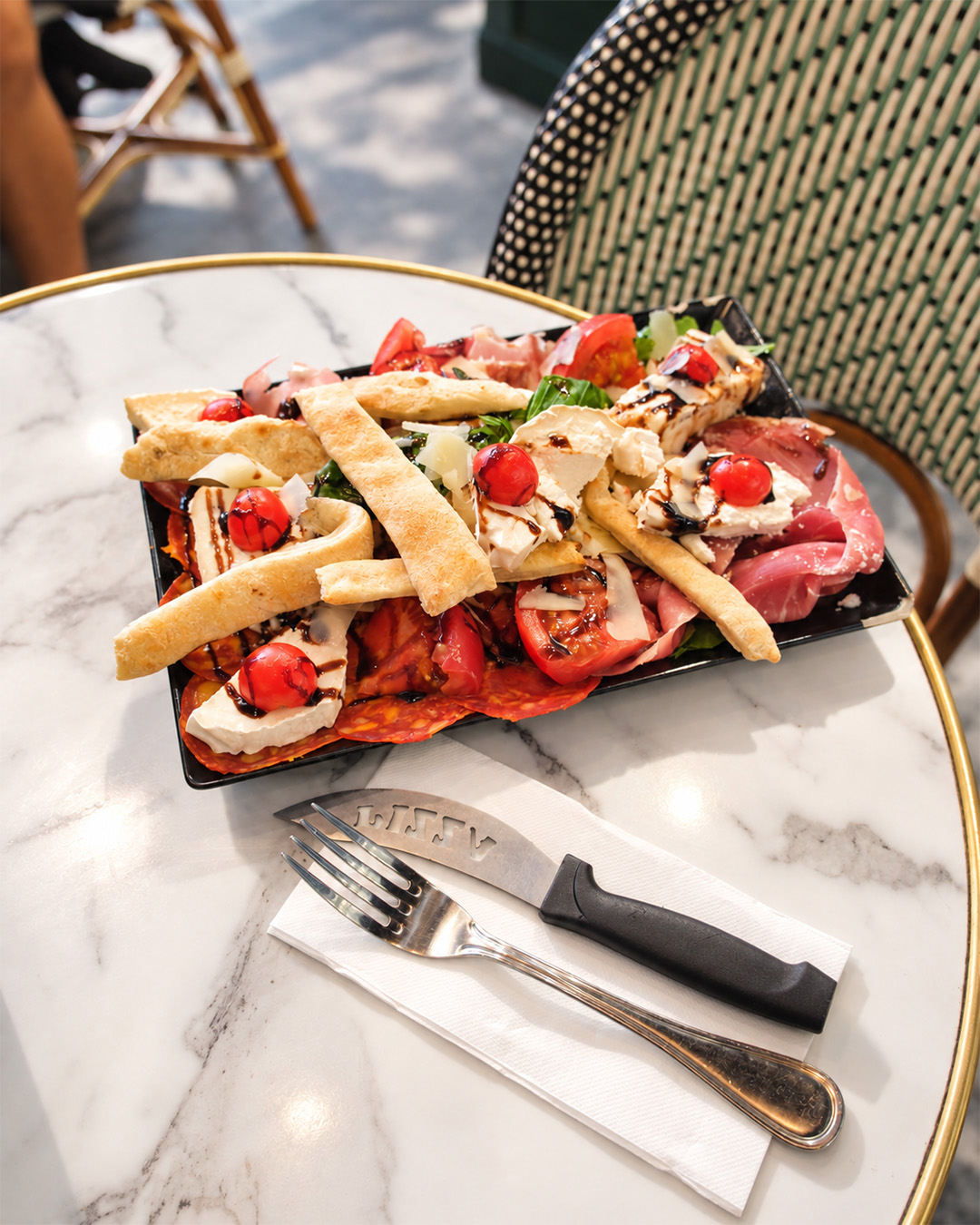 Assiette généreuse de charcuteries, fromages, tomates et grissini
