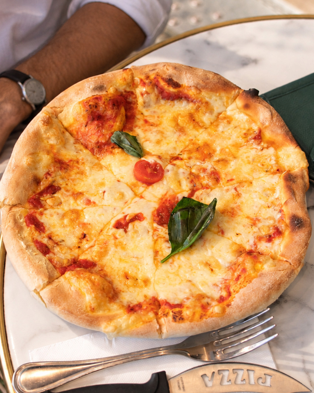 Pizza au fromage et à la tomate servie sur une table en marbre