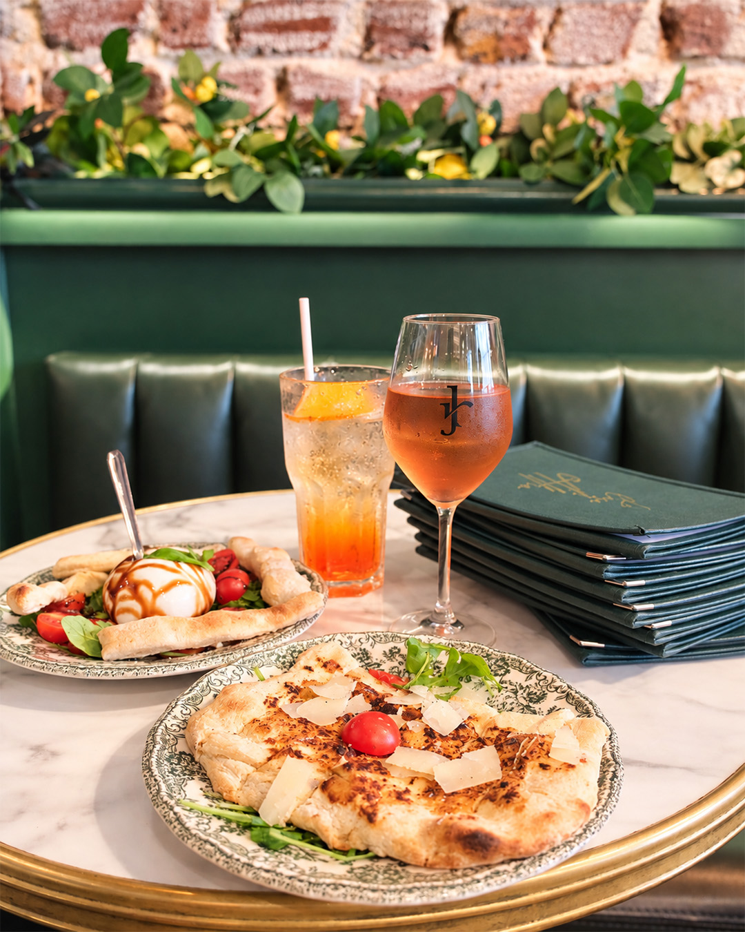 Table de trattoria avec plats italiens, boissons et menus verts La Casa di Alfio
